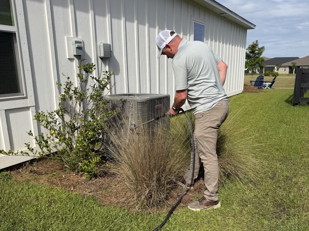Magnolia Air Solutions technician servicing an outdoor AC unit at a Mobile-area home