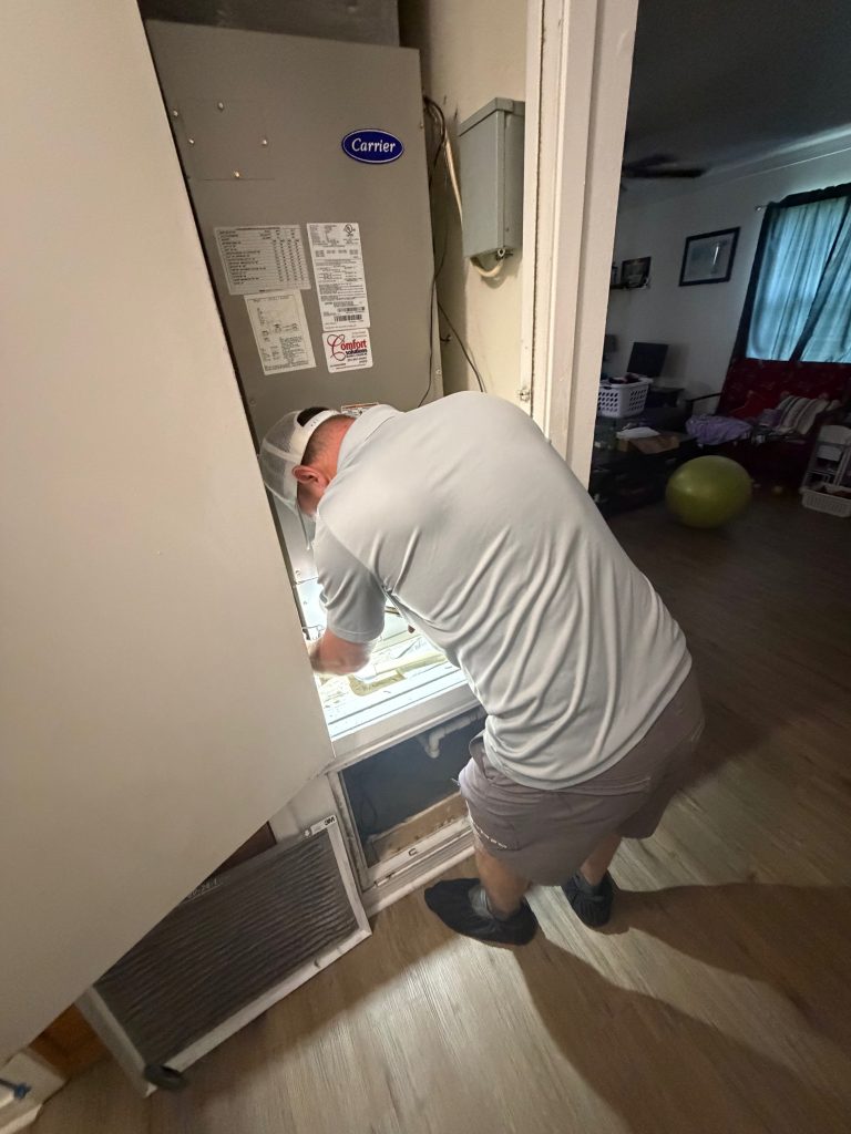 HVAC technician checking the cause of high indoor humidity in a Mobile Alabama home